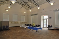 A large open room with 2 covered tables and chairs along the wall with high ceilings